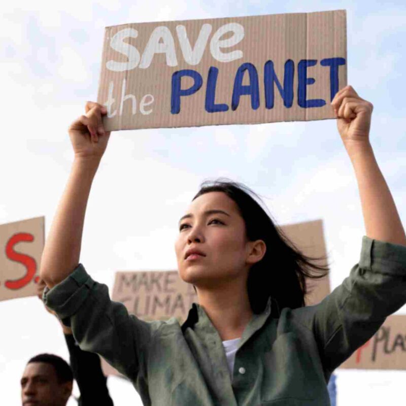 A young activist holds a "Save the Planet" sign at a climate protest, symbolizing youth-driven environmental advocacy and action.