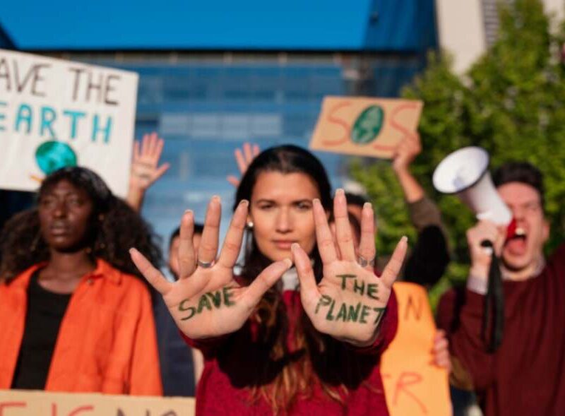 Environmental activists holding signs and advocating for climate action, symbolizing global efforts to address climate change.