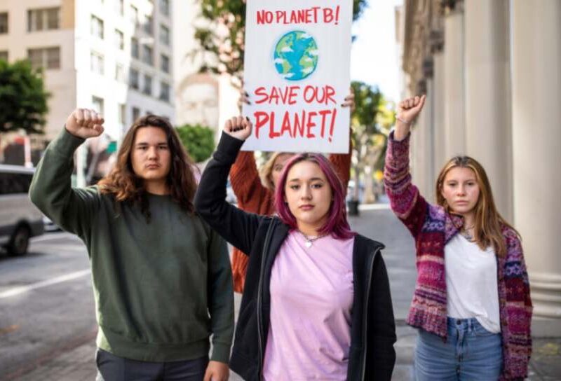 Young activists hold a sign reading 'No Planet B, Save Our Planet' at a climate protest, symbolizing environmental justice advocacy.
