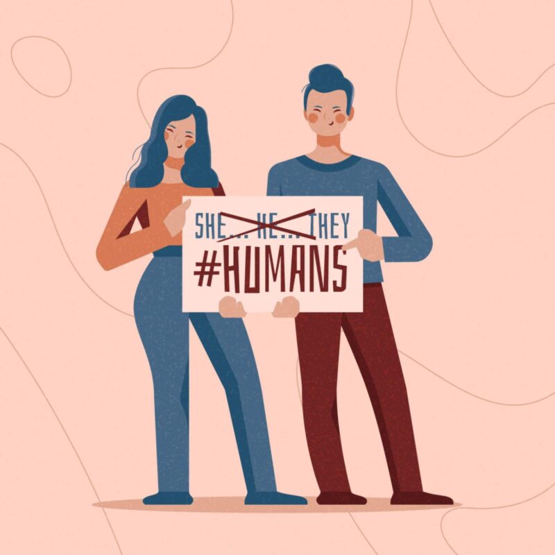 Two people holding a chart where "He," "She," and "They" are crossed out, and "Humans" is checked, representing a shift towards gender inclusivity and neutrality